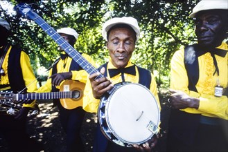 Banjo player at the Caribbean Music Village. A musician holds up his banjo as his band prepare to