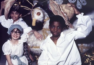 Children at a Commonwealth Institute festival. Children in costume pose beside a large-scale model