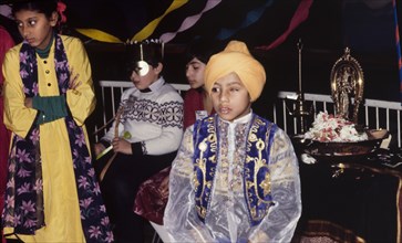 Boy in traditional Indian dress. A young turbaned boy in traditional Indian dress attends a