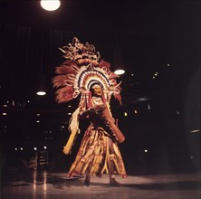 Papua New Guinean performance. A male dancer dressed in a ceremonial costume from Papua New Guinea