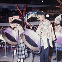 Children playing steelpans. Two Trinidadian children play steelpans on stage during a cultural