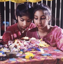 Candles for Diwali. Two girls in traditional Indian dress light candles for Diwali, the Hindu