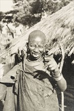 Portrait of a Kikuyu woman. Portrait of a smiling Kikuyu woman gesturing at the camera. Her head is