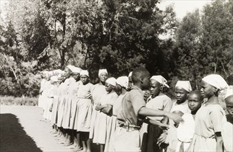 Kikuyu students at a mission school. Young Kikuyu women are lined up outdoors at the Church of
