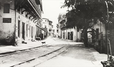 Quiet street in Mombasa. Tram lines run along the centre of a quiet street flanked by