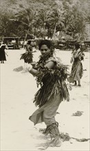 A Fijian dancer. A Fijian woman performs a traditional dance on a beach, dressed in ceremonial
