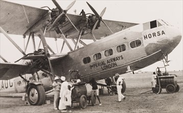 Refueling an Imperial Airways biplane, Kenya. Ground crew refuel an Imperial Airways long-range