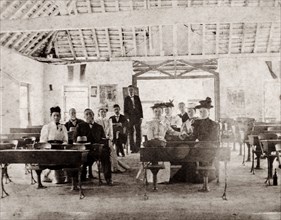American missionaries in a Jamaican school. A group of American missionaries sit or stand by desks