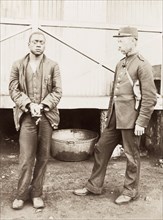 Boer policeman guarding a prisoner. A Boer policeman guards a handcuffed African prisoner during