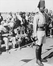 Awaiting the arrival of Princess Elizabeth. An askari (soldier) stands to attention in front of a