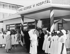 Hospital staff prepare for a royal visit. Nurses and hospital officials assemble outside the King