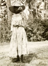 Grenadian woman smoking a pipe. Outdoors portrait of a Grenadian woman wearing a Western-style
