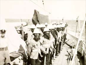 King Neptune's bodyguard. Crew members aboard the HMS Dauntless line up on deck dressed in fake