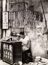A mould maker, Hong Kong. A Chinese mould maker sits at his street stall, carving seals and cake