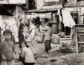 A squatter's settlement in Kowloon. Domestic scene in a Kowloon squatter's settlement. A woman