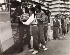 Children queuing for food, Hong Kong. City children queue outside a resettlement block in Kowloon,