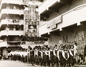Hong Kong schoolchildren. Uniformed schoolchildren queue in separate lines of boys and girls as