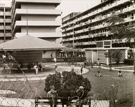 Resettlement blocks in Kowloon. Children play in a fenced park surrounded by multi-storey