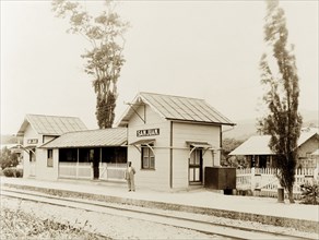 San Juan railway station, Trinidad. A solitary figure waits on the platform at the newly completed