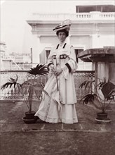 Minnie Murray in Edwardian dress. Full-length portrait of Minnie Murray, taken on a rooftop balcony