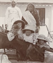 British children in a sedan chair. An Indian servant and ayah (nursemaid) watch over four young
