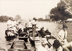Henley Royal Regatta, 1929. Spectators gather on punts on the River Thames to watch a boat race at