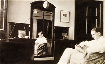 Feeling homesick in Calcutta. James Murray sits reading in his bedroom in Calcutta, homesick for