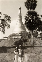 Tourists at the Shwe Dagon Pagoda. British tourists pose in front of the golden dome of the Shwe