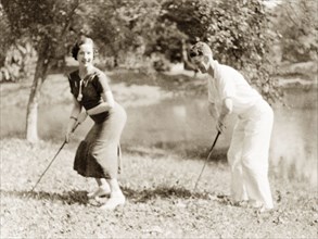 Striking a pose with golf clubs, Calcutta. A European couple strike a pose for the camera holding