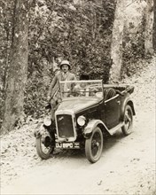 Dr Tweedie posing by his Austin 7. Dr Reid Tweedie poses by his Austin 7 car on a rural road in the
