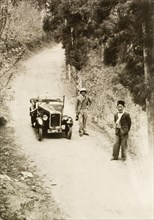 Posing by an Austin 7, Assam. Dr Reid Tweedie, accompanied by his head servant, poses by his Austin