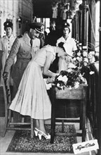 Queen Elizabeth II in Aden, 1954. Queen Elizabeth II signs a guest book during a visit to Aden,