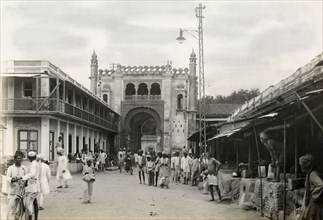 Gateway on city street, Jaora. View along a bustling city street to a large, Islamic-style arched