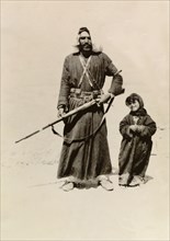 Bedouin father and daughter. Portrait of a bedouin man holding a rifle, who stands in the