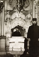 The Tomb of Christ, Jerusalem. Two monks pose beside the Tomb of Christ in the Church of the Holy
