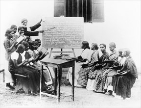 English lesson at a mission school, India. An Indian teacher points to a blackboard as he gives an