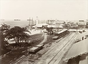 Port of Spain wharf. Empty freight cars and passenger carriages sit on sidings at Port of Spain
