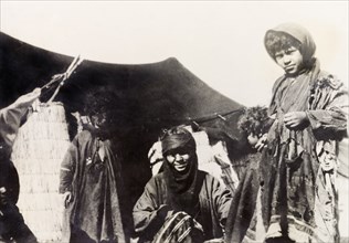 A bedouin family, Palestine. A bedouin family at the entrance to their tent. British Mandate of
