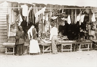 Stall at a 'shuk', Palestine. Shoppers browse a variety of items for sale on a stall at a 'shuk'