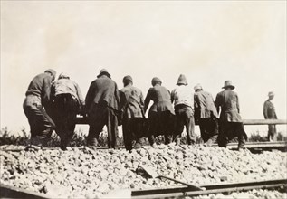 Relaying railway lines, Palestine. A team of labourers relay a stretch of railway track following a
