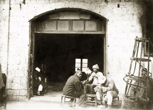 A Palestinian cafe. A group of Arab men socialise in the doorway of a cafe. British Mandate of