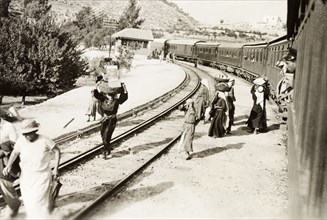 On the Jerusalem railway line. Passengers balance baskets on their heads as they disembark from a