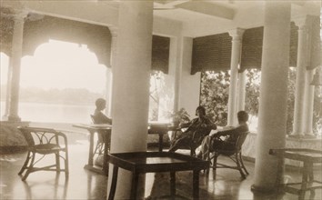 Relaxing on the veranda near Calcutta. Three British women relax in cane chairs on the veranda of a