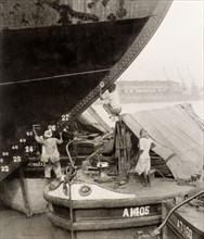 How to paint a ship when you don't have a ladder'. Three dock workers on a river barge attempt to