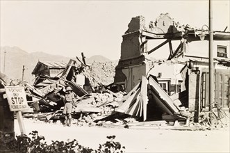 Earthquake damage in Quetta, 1935. A European man stands in the debris of a ruined building,