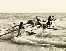 Launching a fishing boat, Puri. Four fishermen launch their fishing boat into the surf at Puri