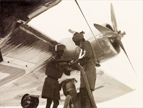 Refuelling 'Euterpe' at Dum Dum Airport. Two Indian airport workers refuel Imperial Airways