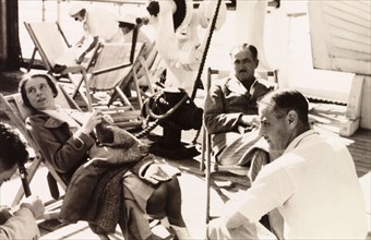 Relaxing on the deck of the Otranto. Passengers relax in deckchairs on the deck of the 'Otranto', a