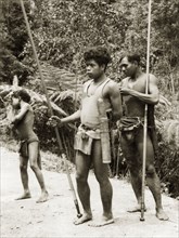 Orang Asli with blow pipes. Two Orang Asli men stand on a rural road, each holding a long blowpipe
