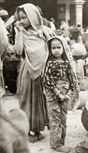 At Darjeeling market. A girls stand in a marketplace in Darjeeling. Both wear traditional dress